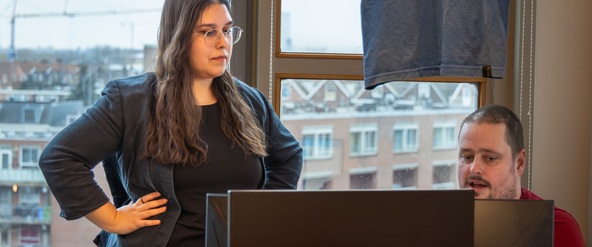Twee collega's in overleg bij een scherm op kantoor bij New Data in Rotterdam