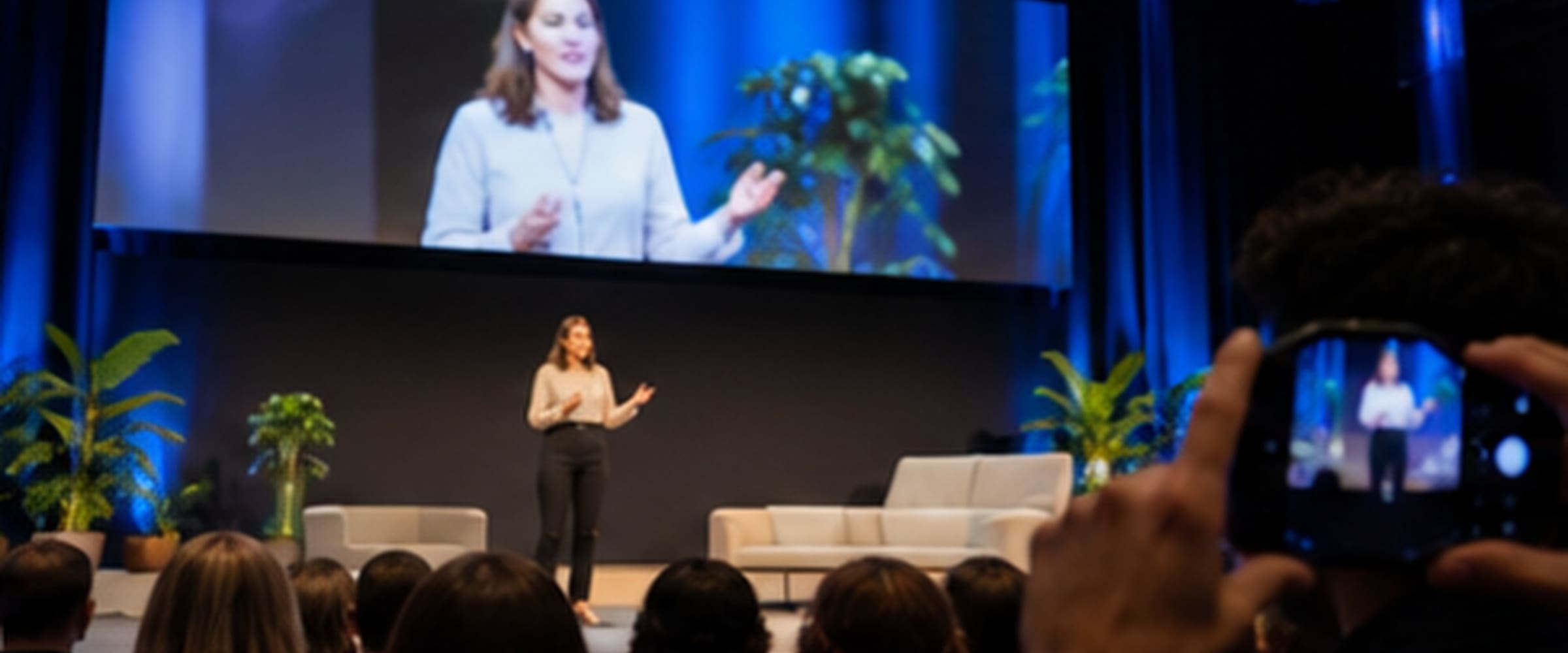 Iemand op een podium voor een zaal met publiek