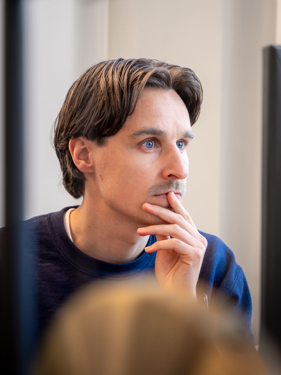 Iemand zit in gedachten, met de blik langs de camera