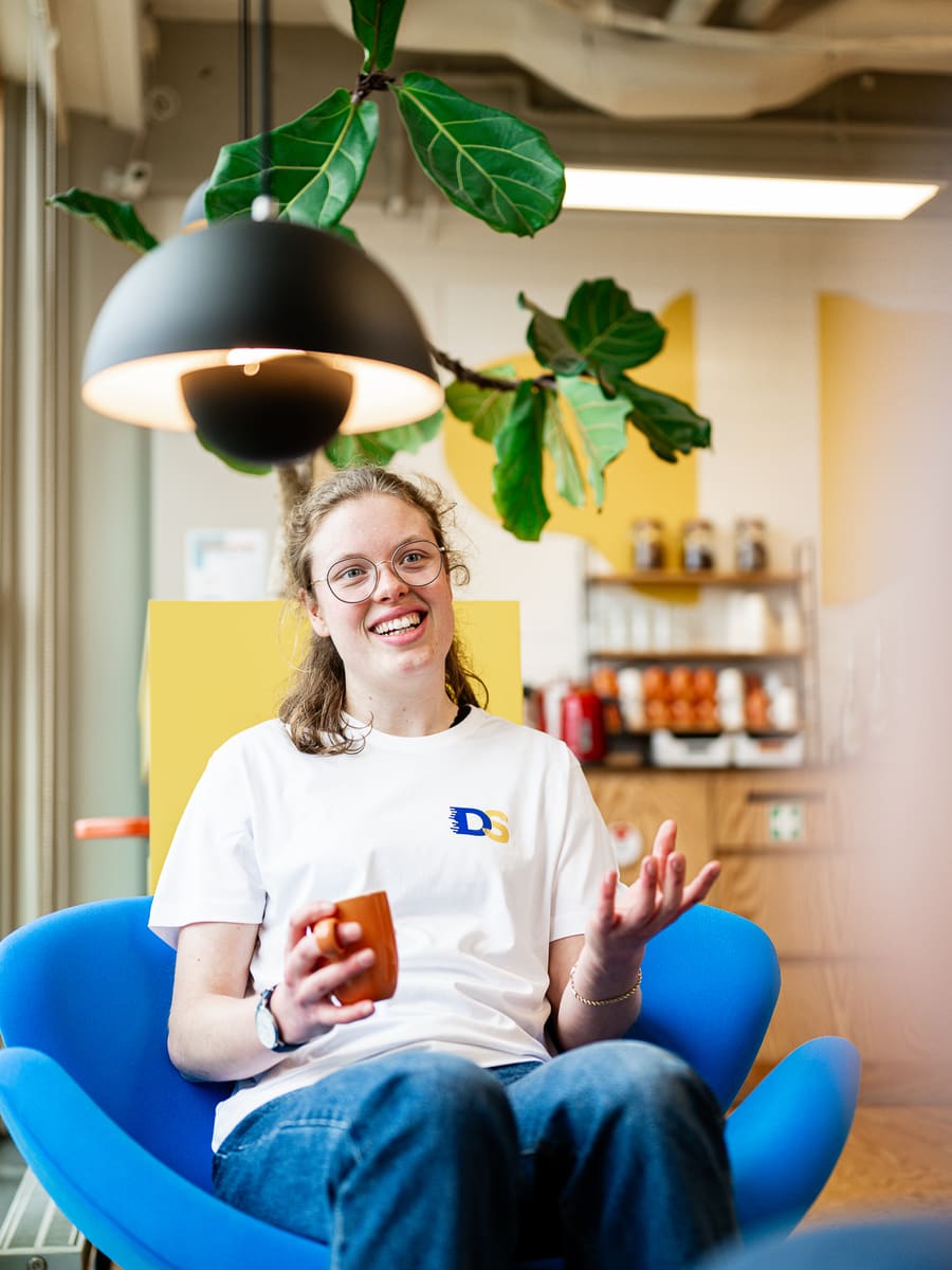 Een collega in een blauwe stoel, in gesprek